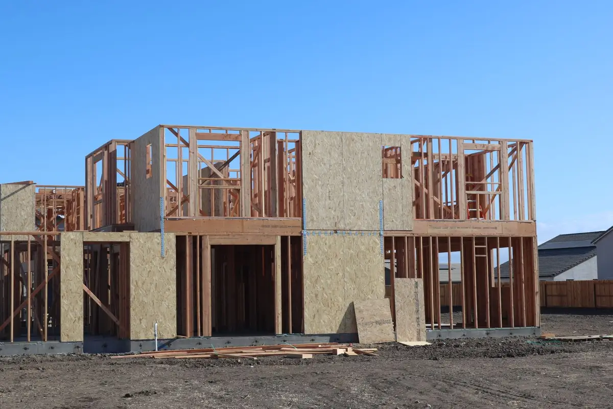 Wood framing for a new home structure under construction on a sunny day